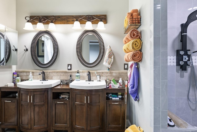 full bath featuring double vanity, a tile shower, and a sink