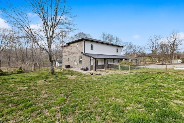 back of property with a fenced backyard, a yard, and a patio area