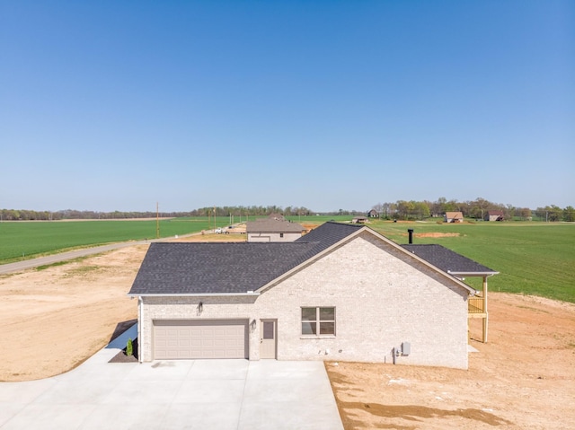 view of front facade featuring an attached garage, a shingled roof, a front lawn, and concrete driveway