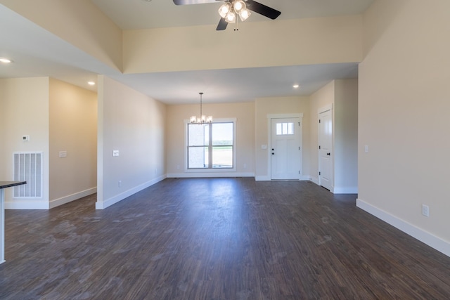 unfurnished living room featuring visible vents, ceiling fan with notable chandelier, baseboards, and dark wood-style floors