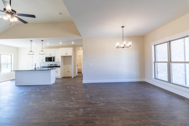 kitchen featuring dark wood-style flooring, stainless steel microwave, white cabinetry, and baseboards