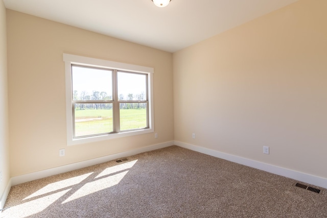 carpeted empty room featuring visible vents and baseboards
