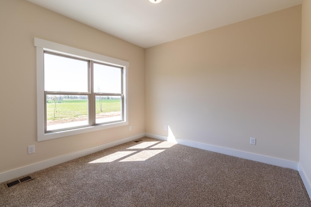 carpeted spare room with baseboards and visible vents