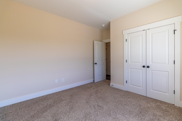 unfurnished bedroom with a closet, baseboards, and carpet floors