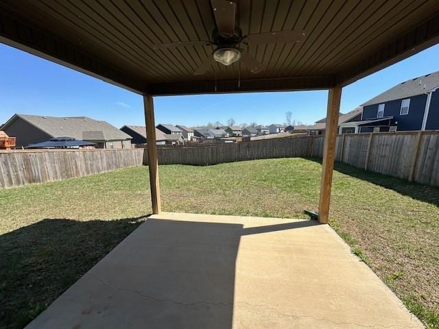 view of yard featuring a patio, ceiling fan, a fenced backyard, and a residential view