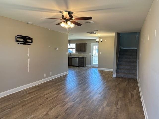 unfurnished living room featuring stairs, dark wood-style flooring, ceiling fan with notable chandelier, baseboards, and visible vents