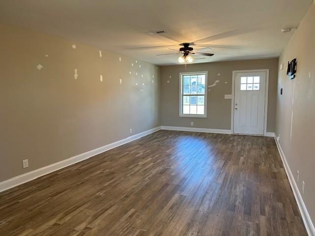 interior space featuring baseboards, ceiling fan, and dark wood-type flooring