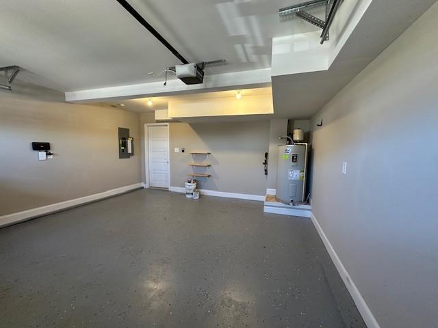 garage featuring baseboards, electric panel, electric water heater, and a garage door opener