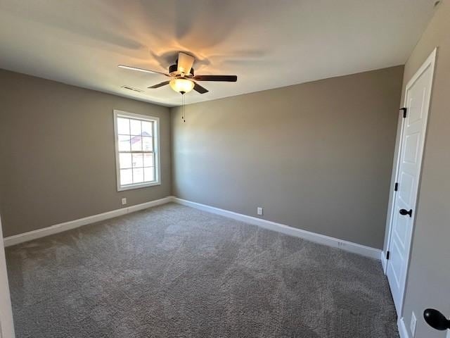 carpeted spare room with a ceiling fan and baseboards