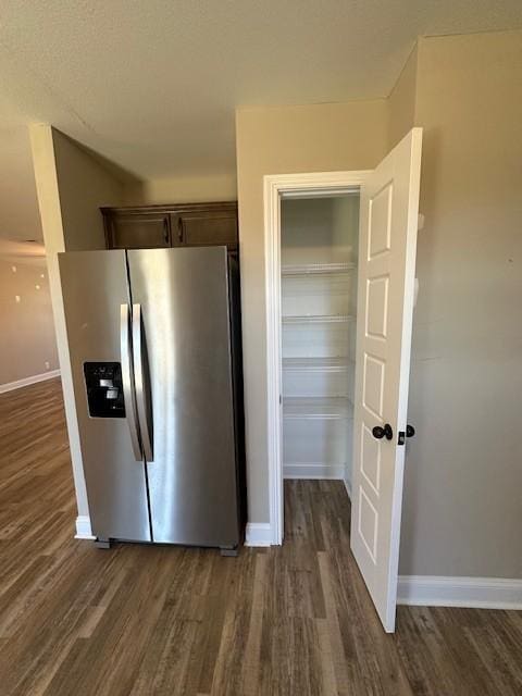 kitchen featuring stainless steel fridge with ice dispenser, dark brown cabinetry, baseboards, and dark wood-style floors