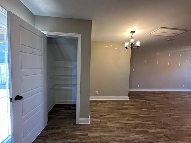 interior space featuring baseboards, wood finished floors, and a chandelier