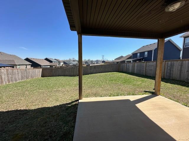 view of yard featuring a fenced backyard, a residential view, and a patio