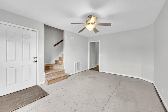 entryway featuring baseboards, ceiling fan, and stairway