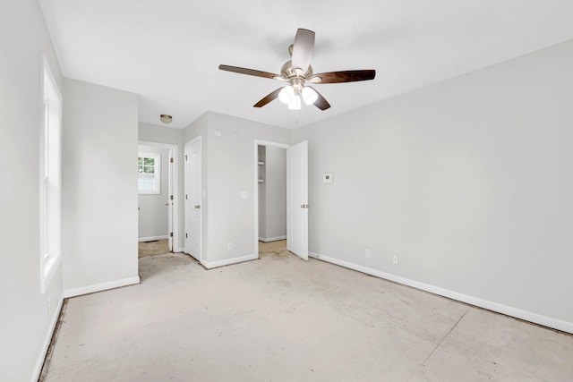 unfurnished bedroom featuring baseboards, a ceiling fan, and concrete floors