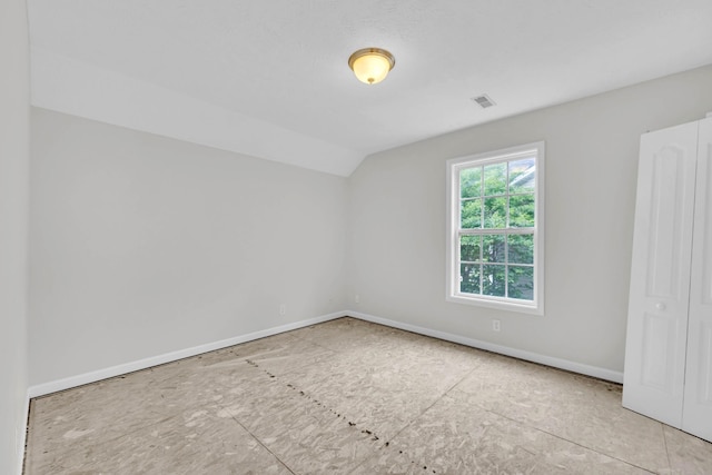 empty room with lofted ceiling and baseboards