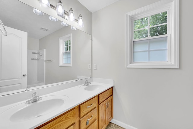 bathroom with double vanity, baseboards, and tub / shower combination