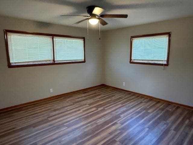 empty room with a ceiling fan, baseboards, and wood finished floors