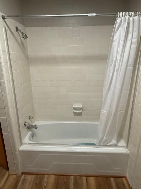 bathroom with shower / bath combo with shower curtain and wood finished floors