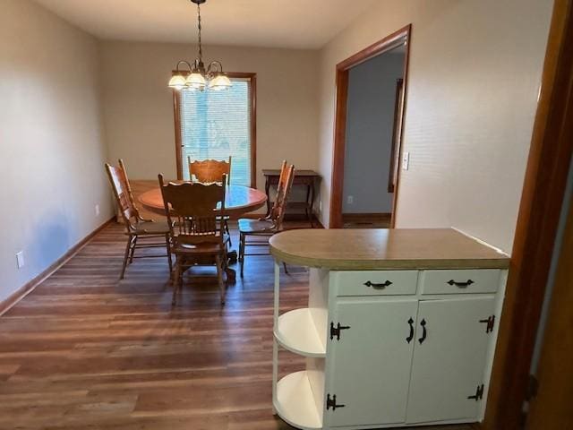 dining room featuring baseboards, a chandelier, and dark wood-type flooring