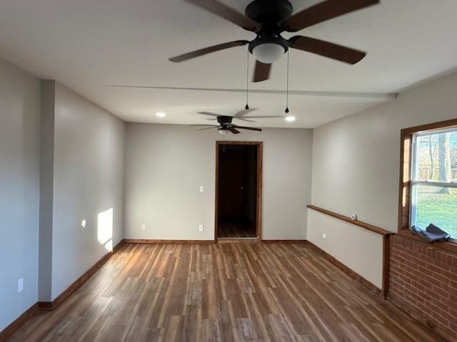 spare room with baseboards, a ceiling fan, and wood finished floors