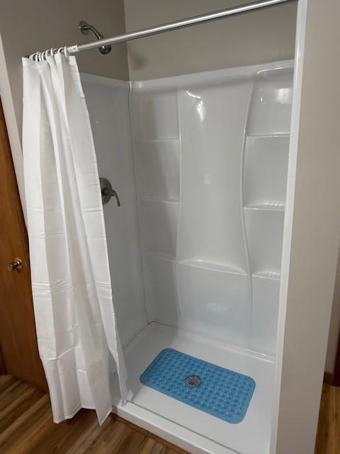 bathroom featuring a stall shower and wood finished floors