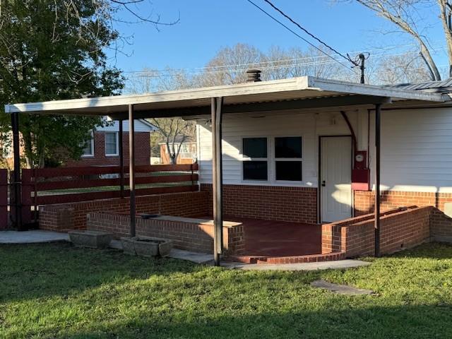 view of home's exterior featuring brick siding, fence, and a yard