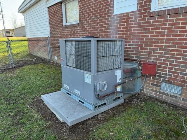 exterior details featuring brick siding, fence, crawl space, and cooling unit
