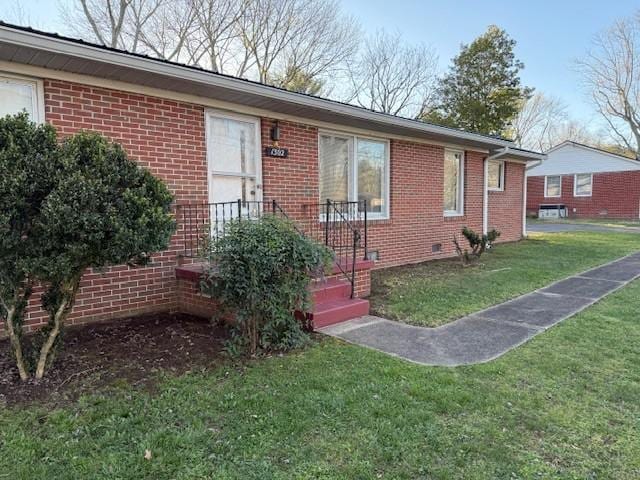 view of front facade featuring brick siding, crawl space, and a front lawn