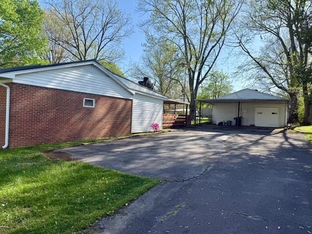 view of property exterior with a garage, driveway, and brick siding