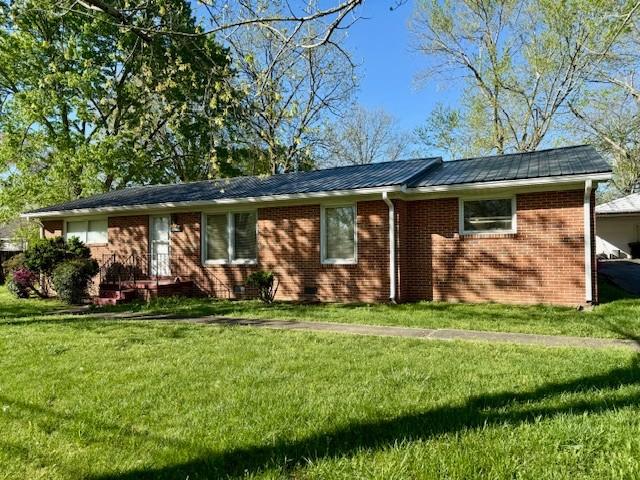 single story home with brick siding and a front lawn