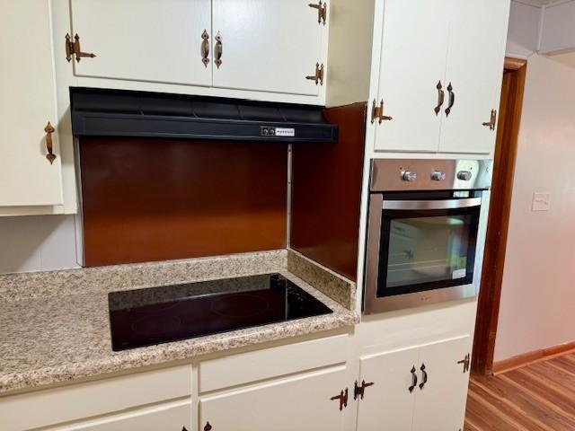1302 Old Estill Springs Rd, Tullahoma, TN 37388 - kitchen featuring stainless steel oven, black electric stovetop, white cabinets, and range hood