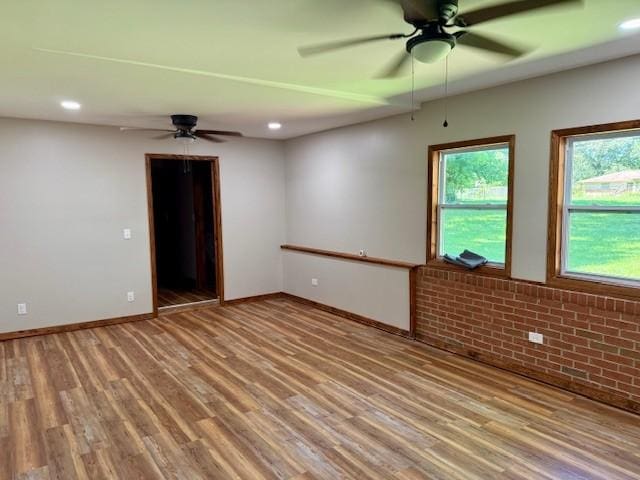 1302 Old Estill Springs Rd, Tullahoma, TN 37388 - spare room featuring ceiling fan, wood finished floors, baseboards, recessed lighting, and brick wall