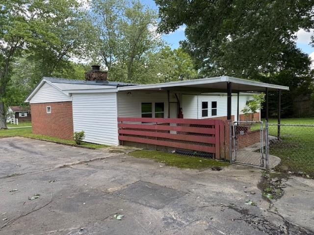 1302 Old Estill Springs Rd, Tullahoma, TN 37388 - view of front facade with a chimney, a gate, and brick siding