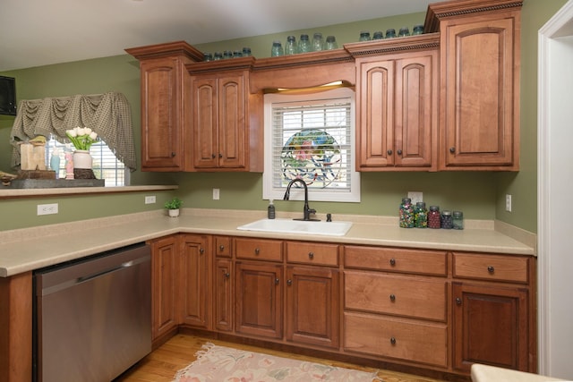 kitchen featuring a sink, brown cabinets, dishwasher, and a healthy amount of sunlight