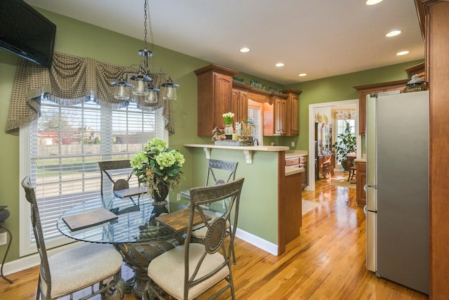 dining room with light wood-style flooring, recessed lighting, and an inviting chandelier