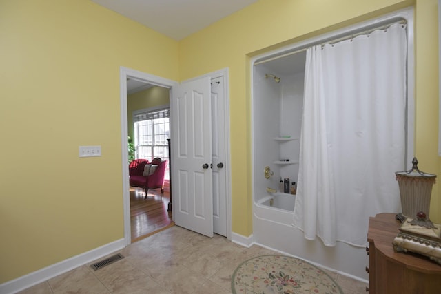 interior space with baseboards, visible vents, and light tile patterned floors