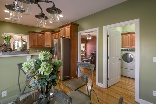 kitchen featuring light wood-type flooring, stainless steel fridge with ice dispenser, baseboards, washer / dryer, and ceiling fan