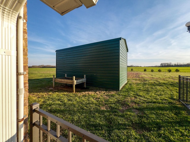 view of yard with an outdoor structure and a rural view