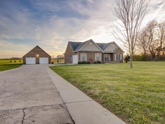 view of front of house featuring an outdoor structure, brick siding, a front yard, and a detached garage