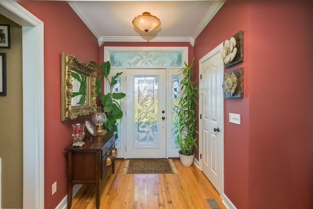 foyer featuring crown molding, light wood finished floors, and visible vents