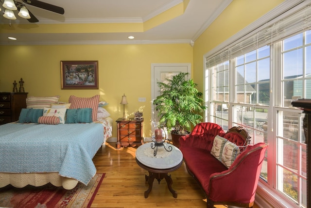 bedroom featuring recessed lighting, crown molding, a tray ceiling, and wood finished floors