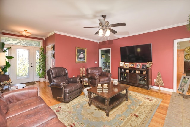 living room with crown molding, baseboards, wood finished floors, and a ceiling fan