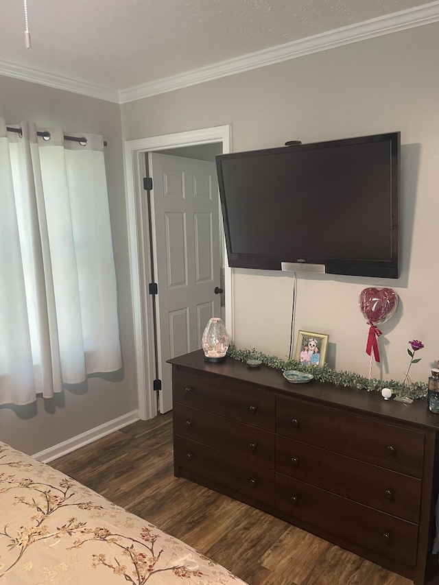 bedroom with ornamental molding, dark wood-type flooring, and baseboards
