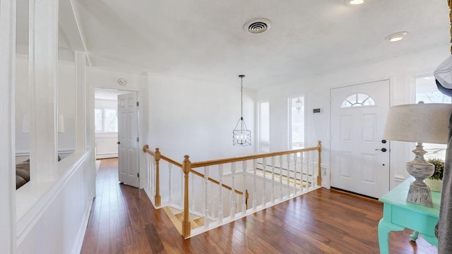 entrance foyer with hardwood / wood-style floors, visible vents, and baseboard heating