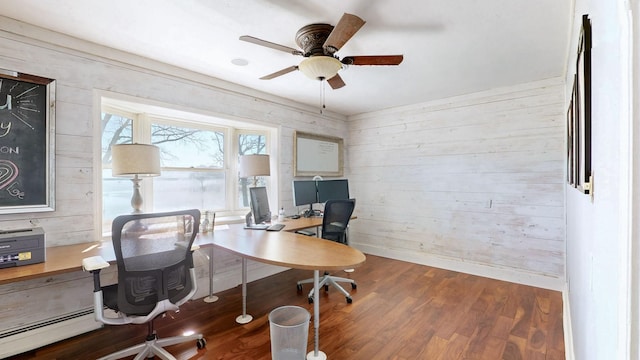 office area with ceiling fan, wood finished floors, a baseboard heating unit, and wood walls