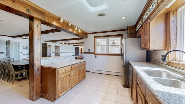 kitchen featuring visible vents, brown cabinets, beam ceiling, a sink, and a baseboard heating unit