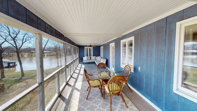 sunroom featuring an outdoor hangout area, a water view, and ceiling fan