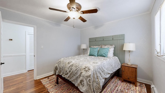 bedroom featuring wood finished floors, ornamental molding, baseboards, a ceiling fan, and baseboard heating