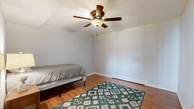 bedroom featuring baseboards, ceiling fan, wood finished floors, and a baseboard heating unit