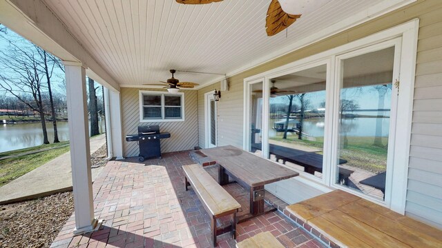 view of patio / terrace featuring a water view, ceiling fan, and area for grilling